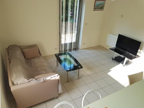 un salon avec un canapé et une télévision dans l'établissement F2 en rez de jardin à Crest, à Crest