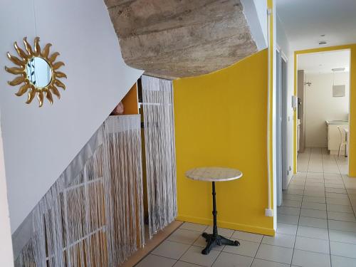 einen Flur mit gelber Wand und einem Tisch in der Unterkunft F2 meublé à Crest in Crest