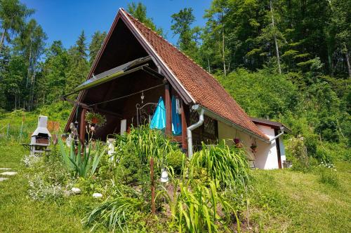 a small house in the middle of a field at Emerald Bell Cottage - Smaragdni Zvonček in Gomilsko