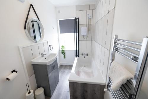 a white bathroom with a sink and a shower at Cosy Home by the Sea in Great Yarmouth in Southtown