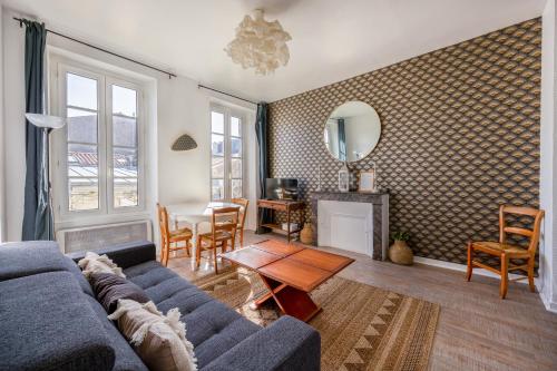 un salon avec un canapé bleu et une table dans l'établissement MYAPPARTLAROCHELLE, à La Rochelle