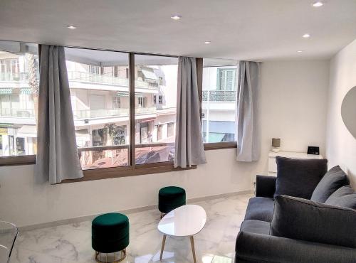 ジュアン・レ・パンにあるRésidence Graziella Appartement 99のソファと2つの窓があるリビングルーム