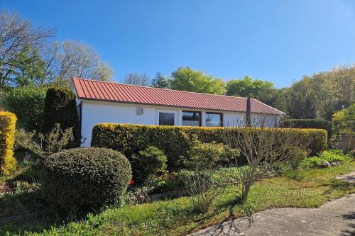 a house with a red roof and some bushes at Bungalow "Refugium" in Ostseebad Sellin