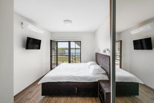 a bedroom with a large bed and a mirror at Reketijos Dvaras in Reketija