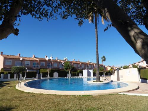 una piscina in un cortile con palme di Casa Mandarina a Els Poblets