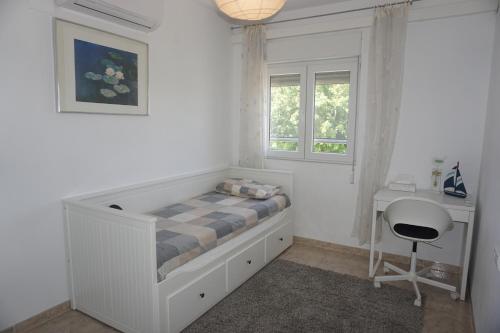 una camera con letto, scrivania e finestra di Casa Mandarina a Els Poblets