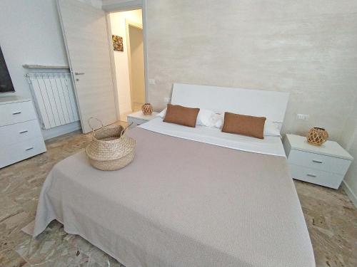 a bedroom with a large white bed with a basket on it at Casa Emmeti in Desenzano del Garda