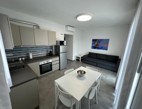 a kitchen and living room with a white table and chairs at Artemisia Home in Olbia