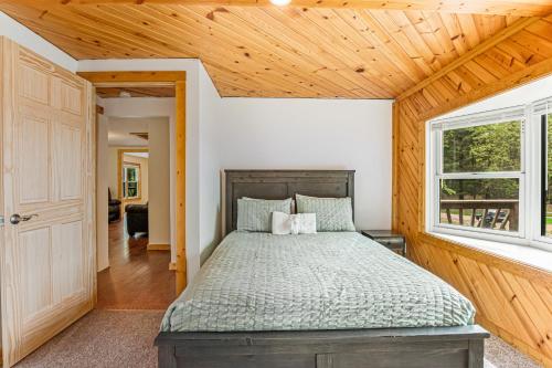 um quarto com uma cama e um tecto de madeira em Moe's Vineyard - Cabin em Necedah