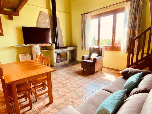 a living room with a couch and a table and a fireplace at Apartamentos Els Ocells in Camprodon