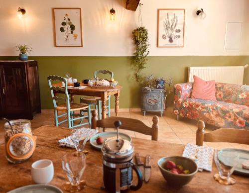 een woonkamer met een tafel en een bank bij Le repaire de la rêveuse in Saint-Frajou