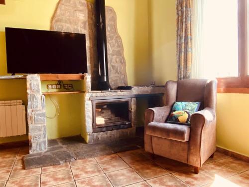 a living room with a chair and a fireplace at Apartamentos Els Ocells in Camprodon