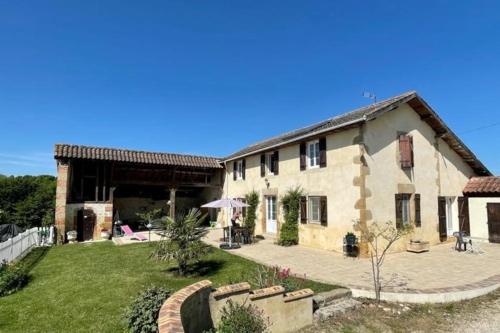 a large stone house with a yard and a courtyard at Maison dans le sud avec piscine chauffée - Midoon Guest in Tillac