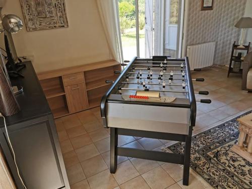 a foosball table in the middle of a living room at Maison dans le sud avec piscine chauffée - Midoon Guest in Tillac