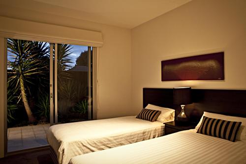 a hotel room with two beds and a window at Brighton Bay Apartments in Melbourne