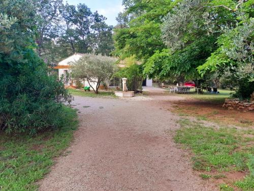 a dirt road leading to a house with trees at Domaine d'Avalon in Lorgues