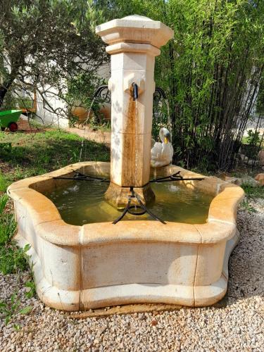 a bird sitting on top of a water fountain at Domaine d'Avalon in Lorgues