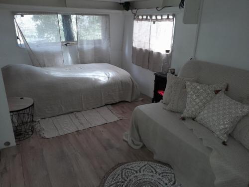 a bedroom with a bed and a couch and a window at Domaine d'Avalon in Lorgues