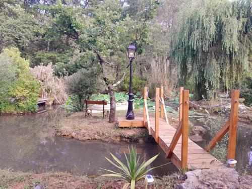 a wooden bridge over a pond with a street light at Domaine d'Avalon in Lorgues