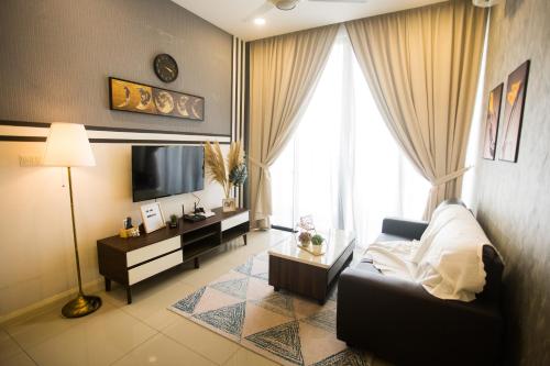 a living room with a couch and a television at D'Pristine Medini By The one - 8min walk to Legoland in Nusajaya