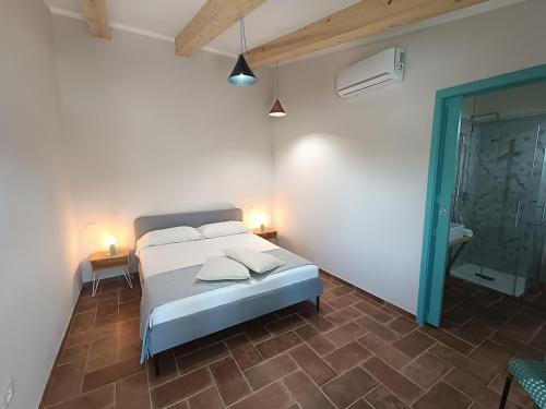 ピオンビーノにあるAgriturismo Al posto giustoの白いベッドルーム(ベッド1台、バスルーム付)
