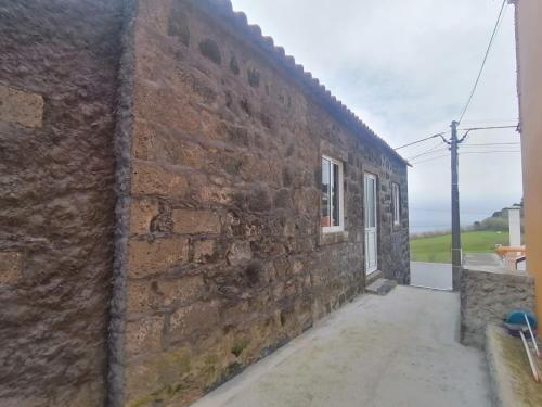a brick wall of a building with a window at Casa C'alma in Ponta Delgada