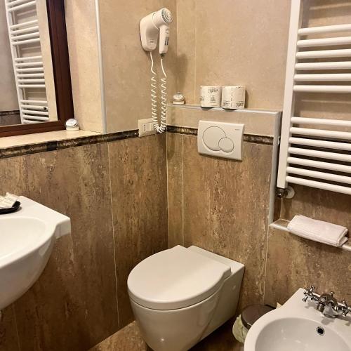 a bathroom with a toilet and a phone on the wall at B&B Podere Cottimellino - Montalcino - Val d'Orcia in Montalcino