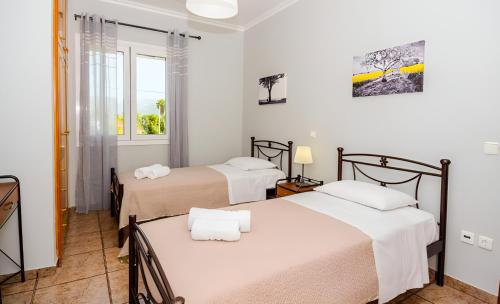 a room with two beds and a window at Aristotelis Apartment Lakithra-Alexandra in Lakithra