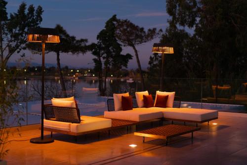 a patio with a couch and a table and lights at Plana Resort & SPA in Castel Volturno