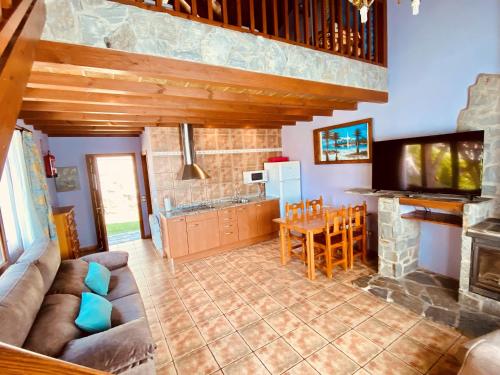 a living room with a couch and a kitchen at Apartamentos Els Ocells in Camprodon
