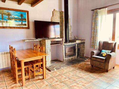 a living room with a wooden table and a fireplace at Apartamentos Els Ocells in Camprodon