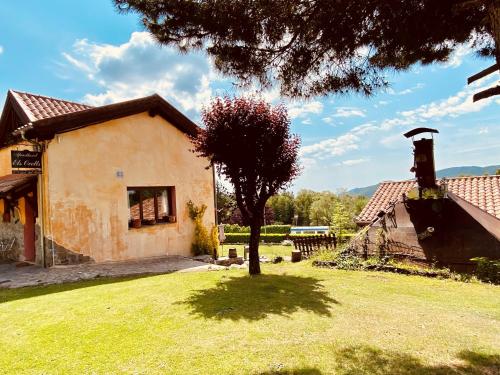 a house with a tree in front of a yard at Apartamentos Els Ocells in Camprodon