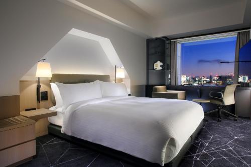 a bedroom with a large white bed and a window at Tokyo Dome Hotel in Tokyo