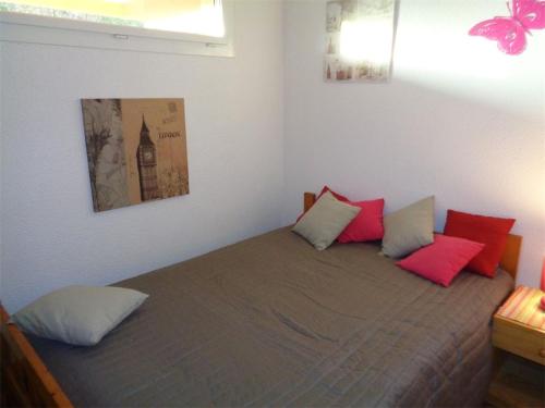 - une chambre avec un lit doté d'oreillers rouges dans l'établissement Appartement T2 avec Piscine et Parking, 4 couchages, proche plage à Argelès-sur-Mer - FR-1-388-2, à Argelès-sur-Mer