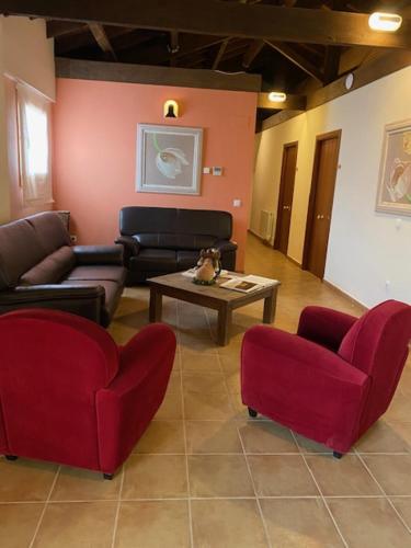 een woonkamer met rode stoelen en een tafel bij LA SOCIEDAD in Arens de Lledó