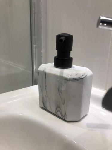 a bottle of soap sitting on top of a bathroom sink at Two Bedroom House Birchington ct79rn in Birchington