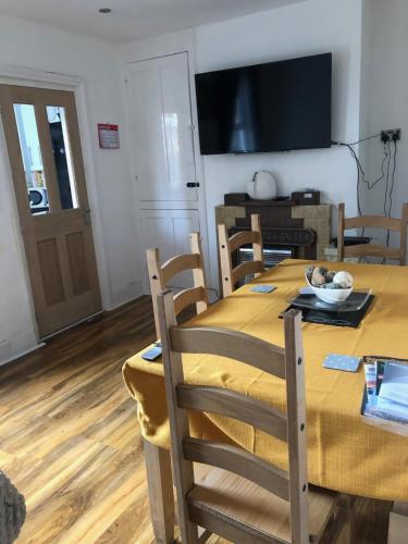 a dining room with a table and chairs and a television at Two Bedroom House Birchington ct79rn in Birchington