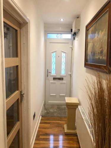 a hallway with a white door with a window at Two Bedroom House Birchington ct79rn in Birchington