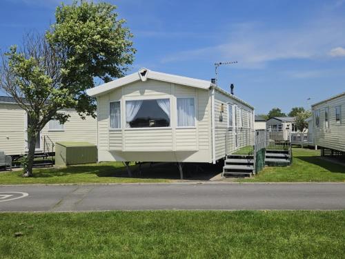 a white mobile home sitting on the side of a street at 6 Berth on John Fowlers (Sandy Glade) Brean in Berrow
