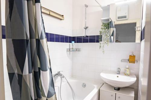 een badkamer met een wit bad, een wastafel en een toilet bij Vienna Living Apartments - Mühlfeldgasse in Wenen