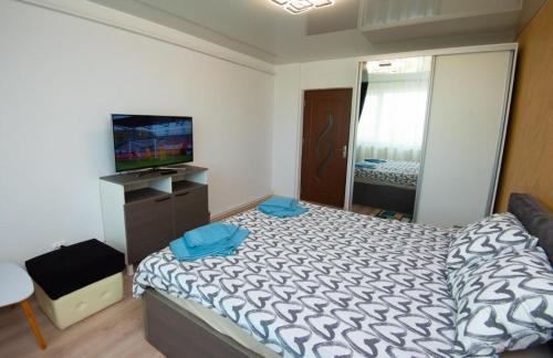 a small bedroom with a bed and a television at Studio zona Țiglina Flori in Galaţi