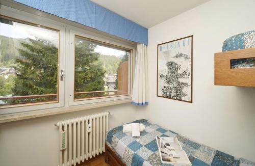 a room with a bed and a window at iFlat Apartment Madonna di Campiglio Casa di Betti in Madonna di Campiglio