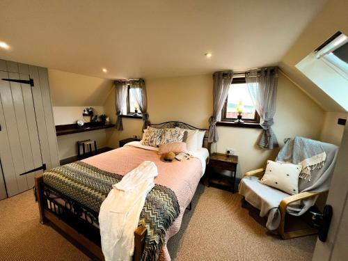 a small bedroom with a bed and a chair at Norfolk Coastal Cottages in Heacham