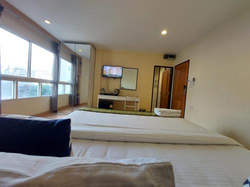a large bedroom with two beds and a television at V Check inn Sukhumvit 22 in Bangkok