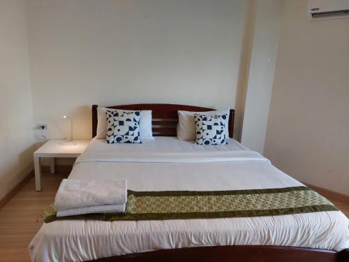 a bedroom with a large bed with blue and white pillows at V Check inn Sukhumvit 22 in Bangkok