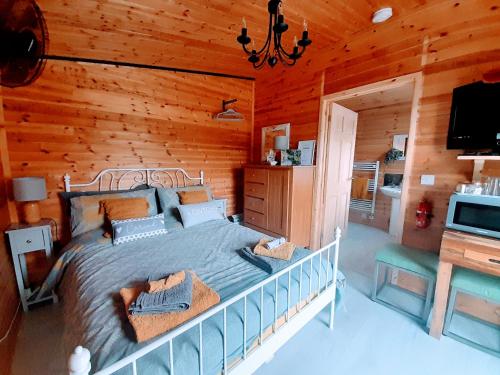 a bedroom with a bed in a log cabin at The Hut B & B in Mochdre