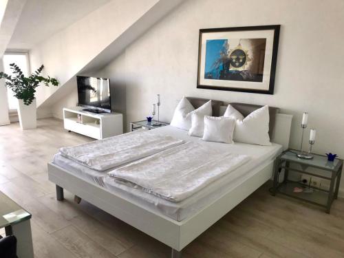 una camera con un grande letto bianco e una TV di Villa Diana a Kaštela (Castelli)