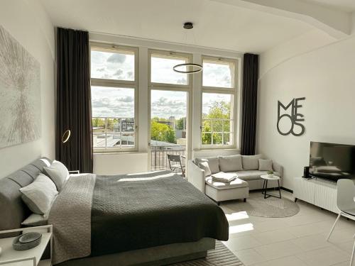 a bedroom with a bed and a living room at MEOS 1 -Zentrum-Balkon-Parkplatz-Gym-Uniklinik in Leipzig