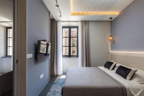 a hotel room with a bed and a television at Apartments and Rooms Lejletul in Dubrovnik