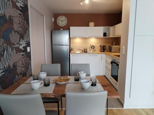 una cucina con tavolo e sedie e una sala da pranzo di Appartement neuf classé, balcon et petite vue mer a Pléneuf-Val-André